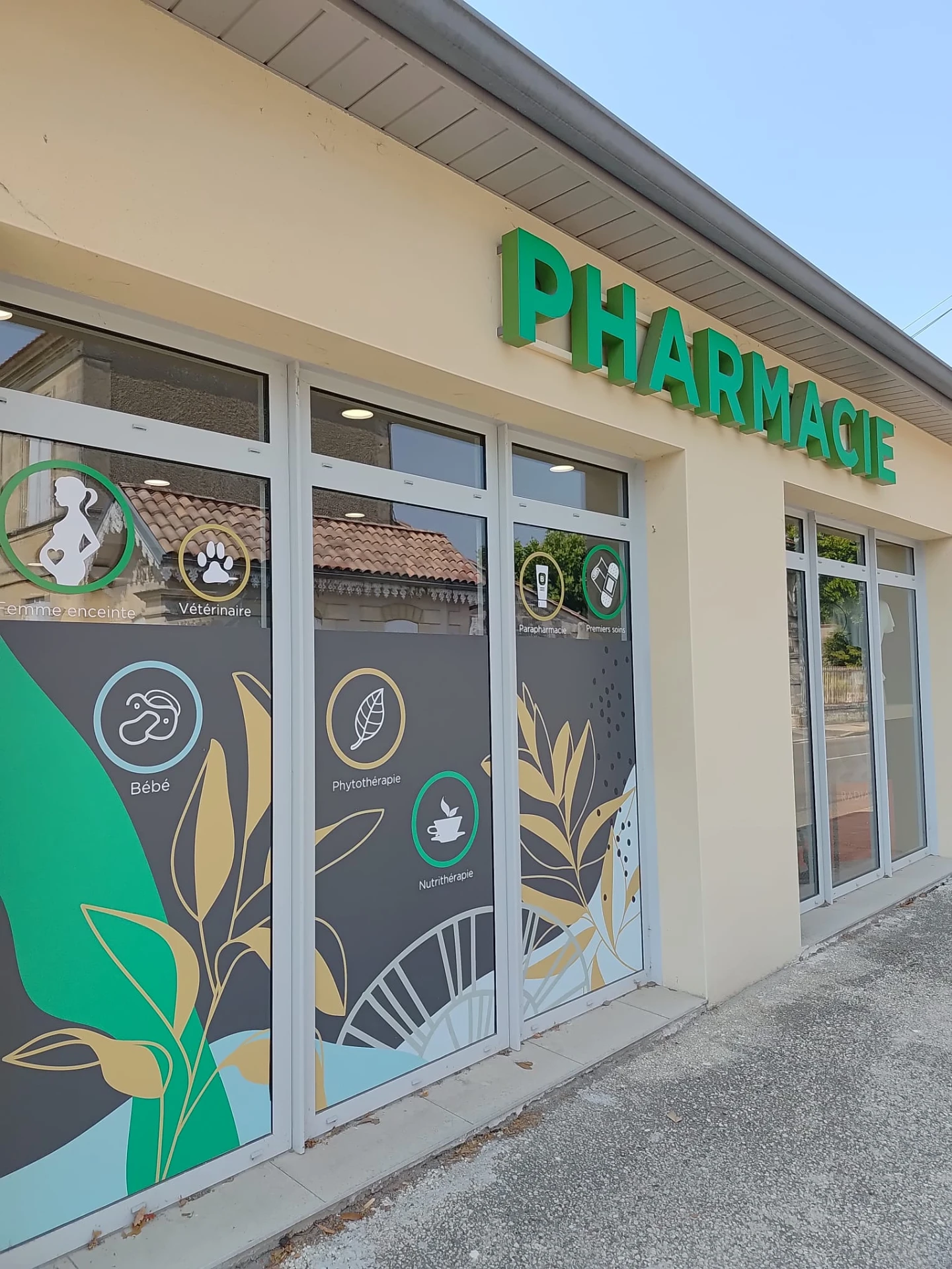 Façade de pharmacie avec enseigne PHARMACIE et vitrophanies