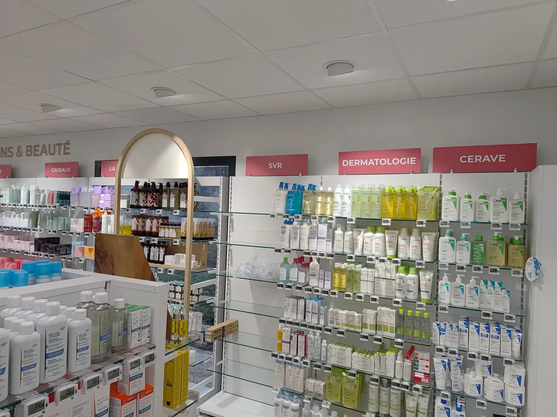 Signalétique intérieure de pharmacie : bandeaux de rayons dermatologie et soins